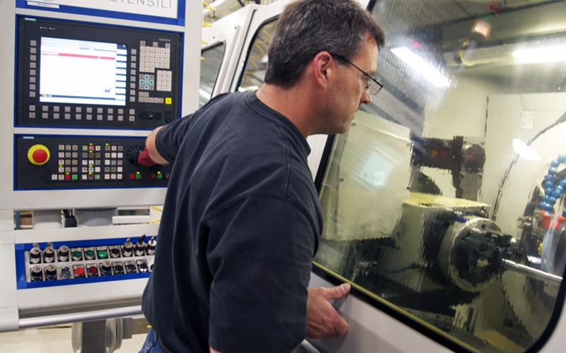 GAMA Automation technician operating a CNC control panel during a retrofit